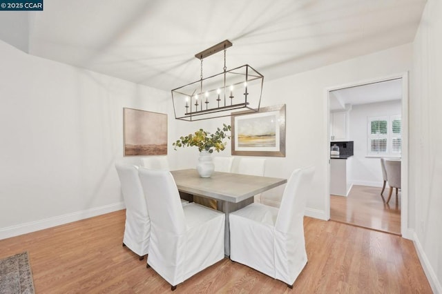 dining area featuring wood-type flooring and a chandelier