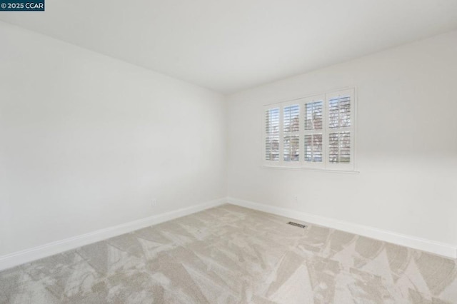 spare room featuring light colored carpet