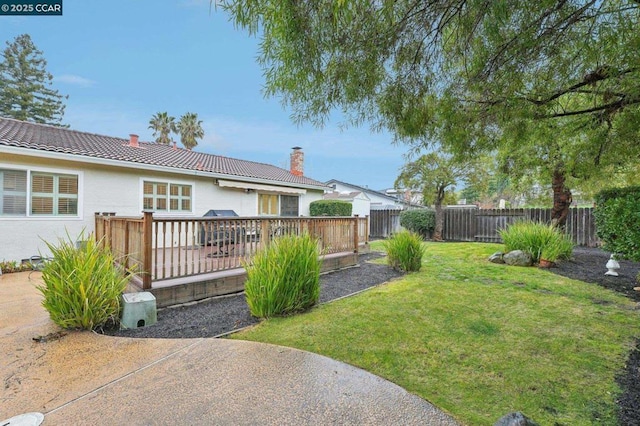 view of yard featuring a wooden deck and a patio