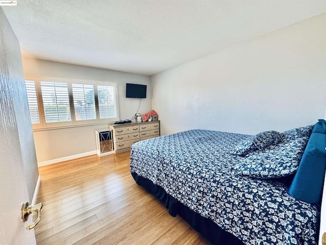 bedroom featuring hardwood / wood-style floors and a textured ceiling