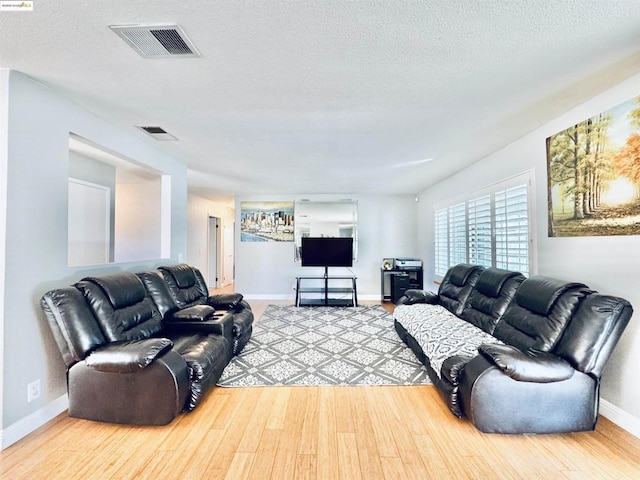 living room featuring light hardwood / wood-style floors and a textured ceiling