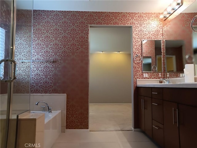 bathroom featuring vanity, a bath, and tile patterned floors