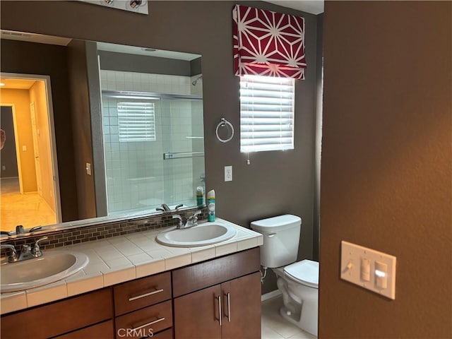 bathroom featuring vanity, toilet, and walk in shower