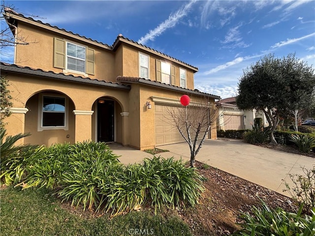 mediterranean / spanish-style home with a garage