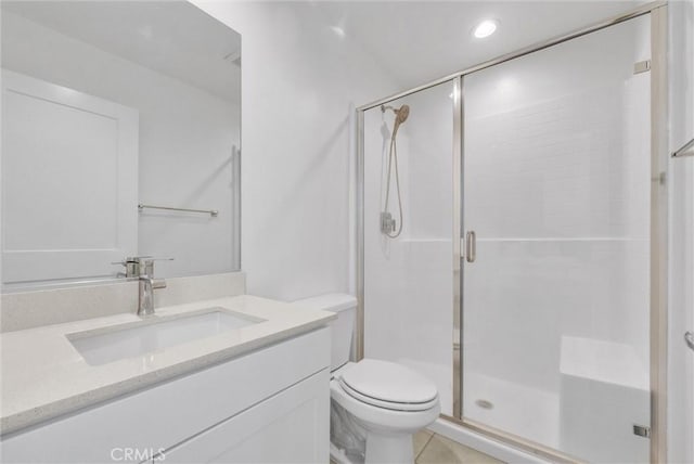 bathroom featuring toilet, vanity, and walk in shower