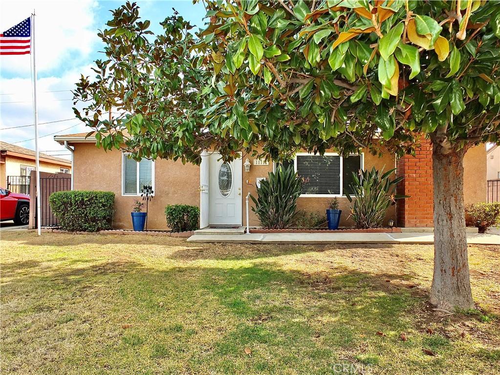 obstructed view of property featuring a front yard, fence, and stucco siding