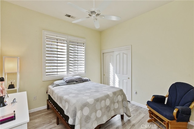 bedroom with ceiling fan, light hardwood / wood-style floors, and a closet