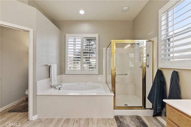 bathroom with hardwood / wood-style flooring and separate shower and tub