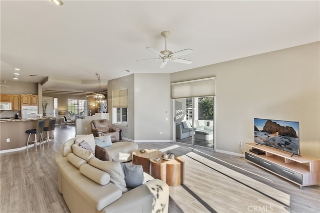 living room featuring ceiling fan and light hardwood / wood-style flooring