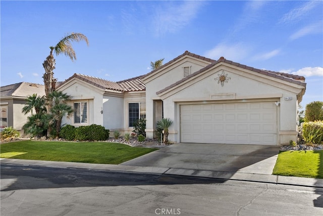 mediterranean / spanish-style home featuring a garage and a front lawn