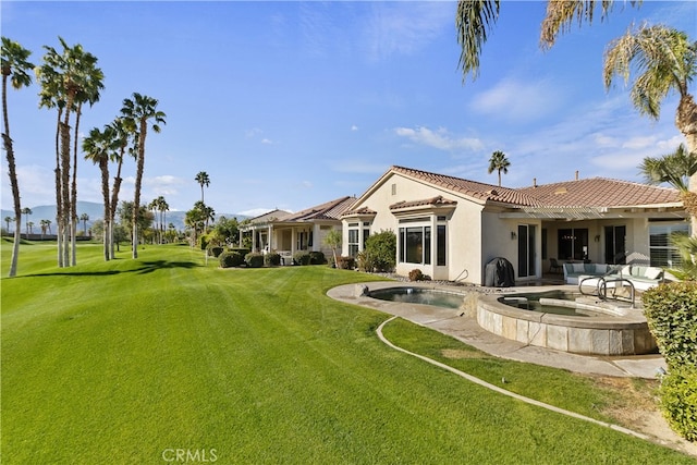 back of property with a yard and a pool with hot tub