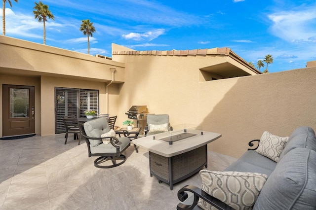 view of patio / terrace with grilling area and an outdoor living space with a fire pit