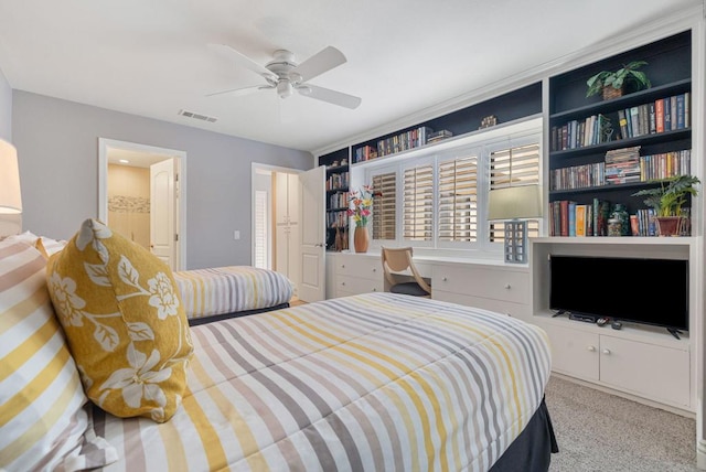 bedroom featuring ensuite bathroom, light carpet, and ceiling fan