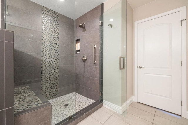 bathroom with an enclosed shower and tile patterned floors