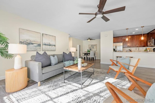 living room with ceiling fan and light wood-type flooring