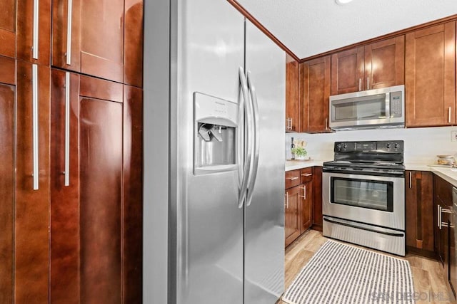 kitchen with stainless steel appliances and light hardwood / wood-style flooring