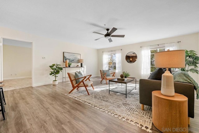 living room with light hardwood / wood-style flooring and ceiling fan