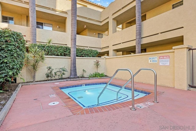 view of swimming pool with a hot tub