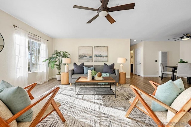 living room with wood-type flooring and ceiling fan