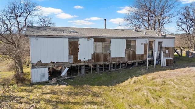 back of property featuring a yard and central AC