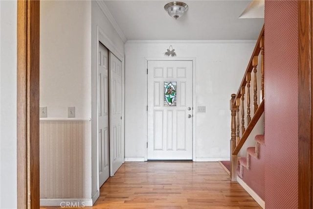 foyer entrance featuring crown molding and light wood-type flooring