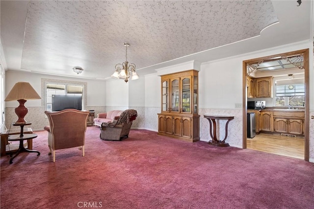 interior space with crown molding, a chandelier, light carpet, and a textured ceiling