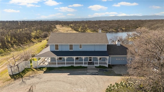 view of front of property featuring a water view, a garage, and covered porch