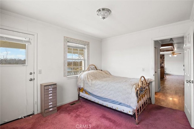 bedroom featuring crown molding, carpet flooring, and multiple windows