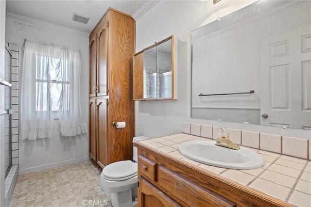 bathroom featuring vanity, crown molding, a shower with shower door, and toilet