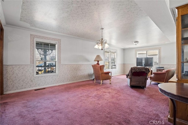 living area with ornamental molding, carpet flooring, a textured ceiling, and a notable chandelier