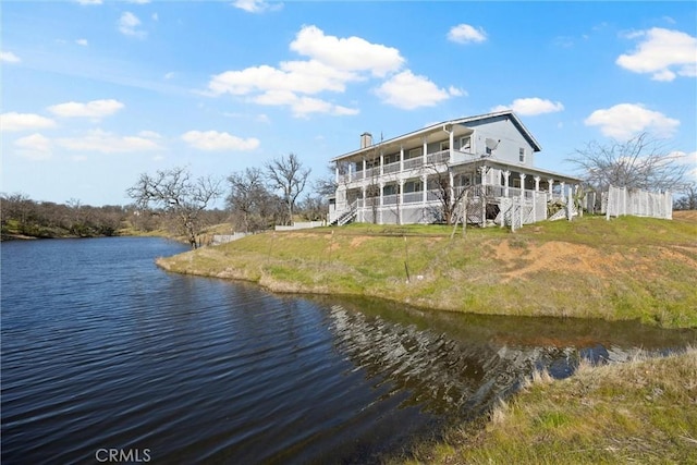 back of property with a balcony and a water view