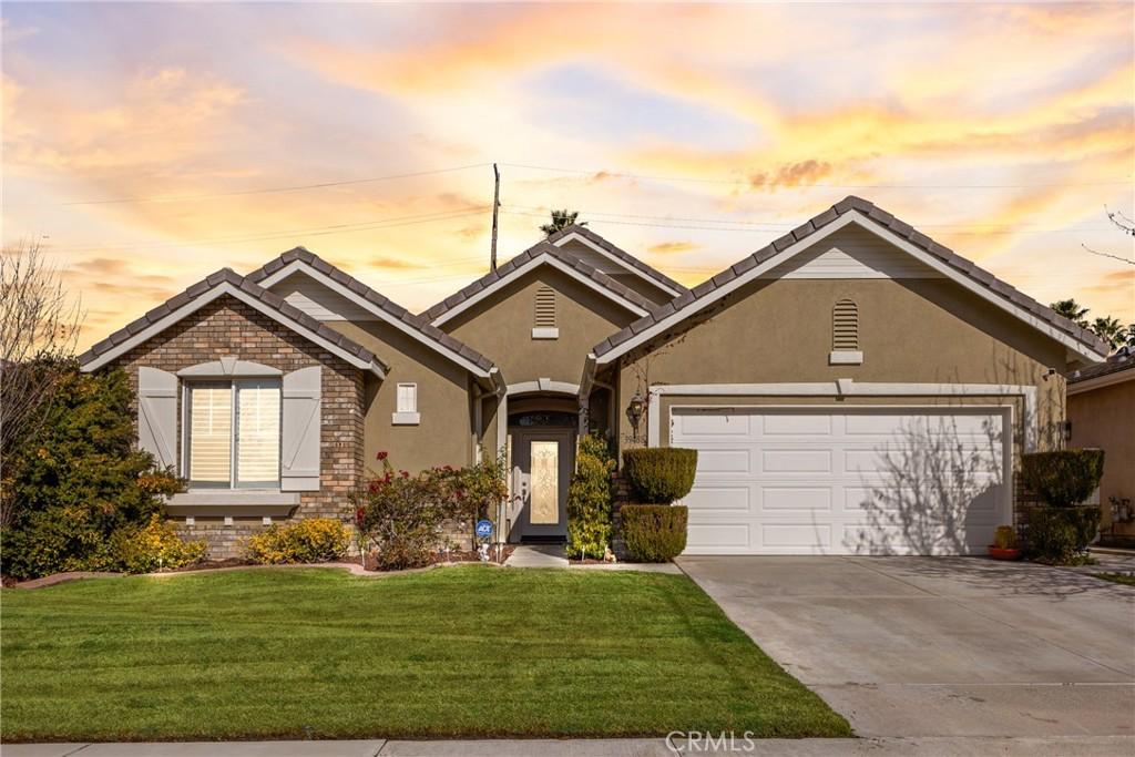 ranch-style house with a garage and a yard