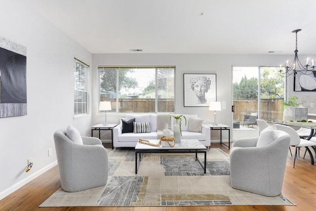 living room with a notable chandelier, hardwood / wood-style flooring, and plenty of natural light