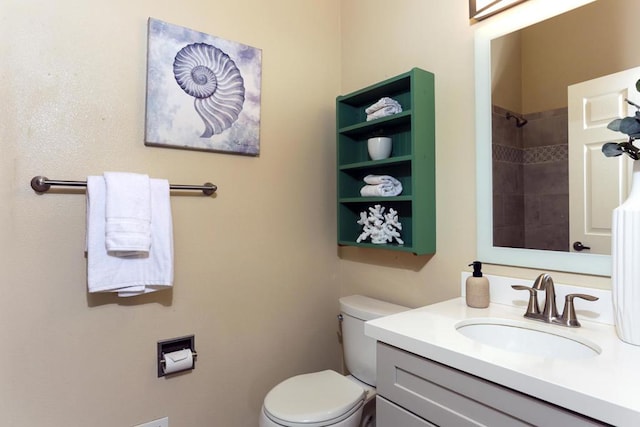 bathroom with vanity, toilet, and a tile shower