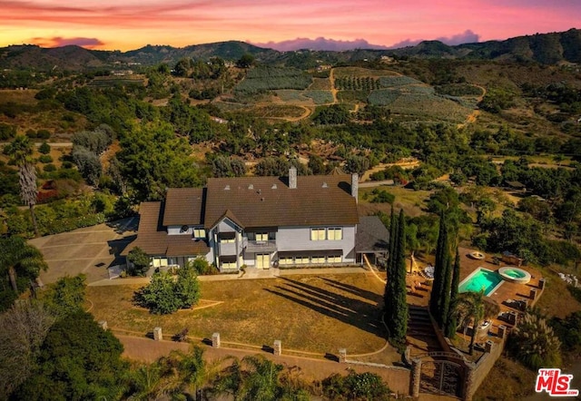 aerial view at dusk featuring a mountain view