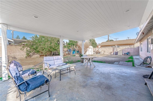 view of patio with outdoor lounge area and a shed