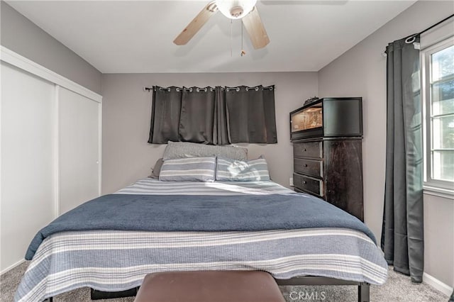 carpeted bedroom with ceiling fan and a closet