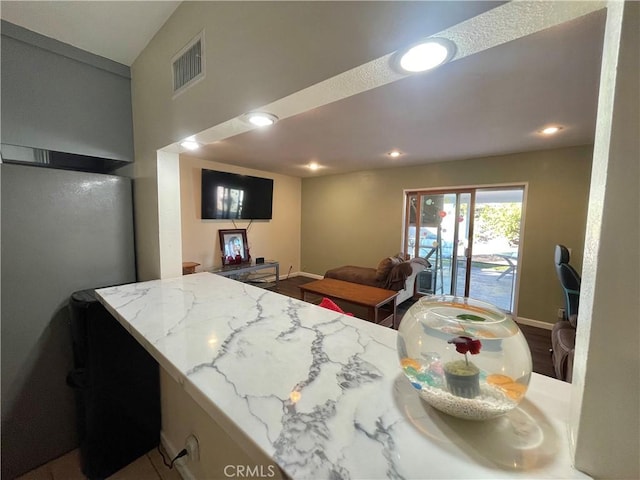 interior space featuring kitchen peninsula and light stone countertops