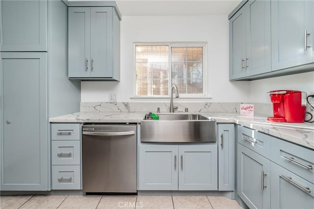 kitchen featuring light tile patterned flooring, sink, stainless steel dishwasher, and light stone counters