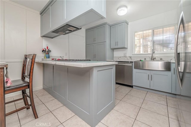 kitchen featuring sink, light tile patterned floors, gray cabinetry, stainless steel appliances, and kitchen peninsula