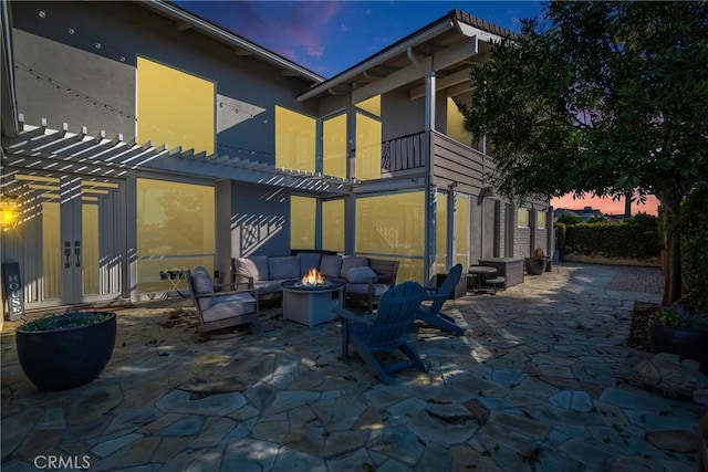 back house at dusk with a patio area and a fire pit