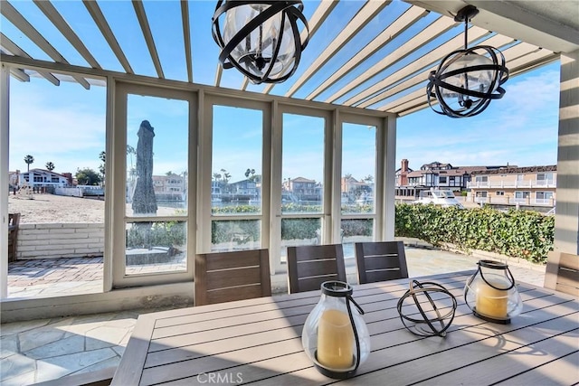 sunroom / solarium featuring an inviting chandelier