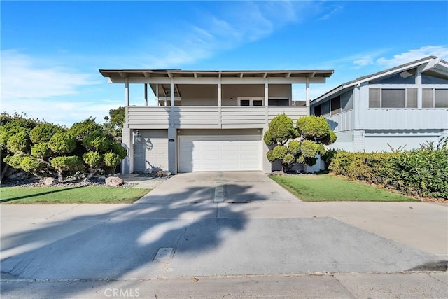 view of front of property with a balcony, a garage, and a front yard