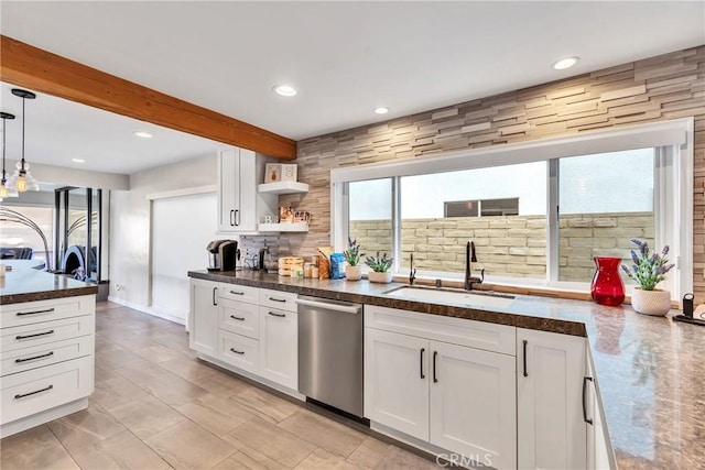 kitchen featuring pendant lighting, dishwasher, sink, and white cabinets