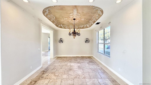 unfurnished dining area with a raised ceiling and an inviting chandelier