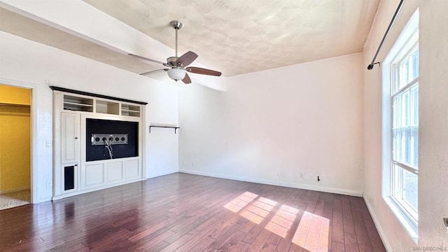 unfurnished living room with dark wood-type flooring, ceiling fan, and plenty of natural light