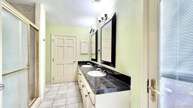 bathroom with vanity, an enclosed shower, and tile patterned flooring