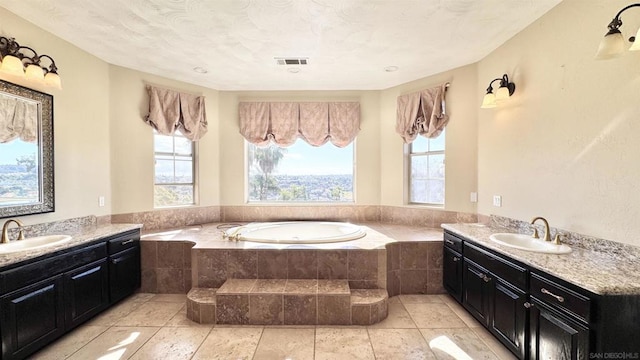 bathroom featuring a relaxing tiled tub and vanity