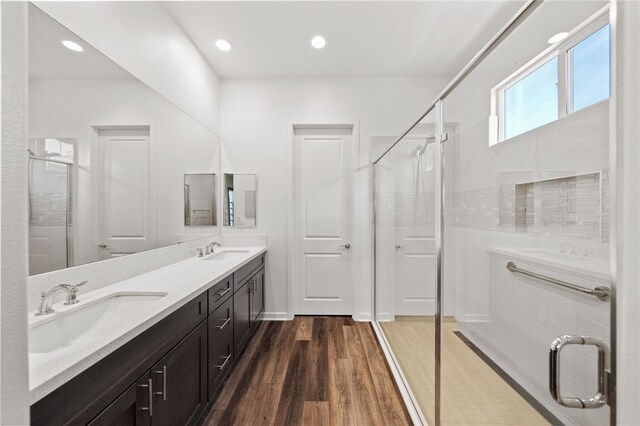 bathroom featuring hardwood / wood-style flooring, vanity, and an enclosed shower