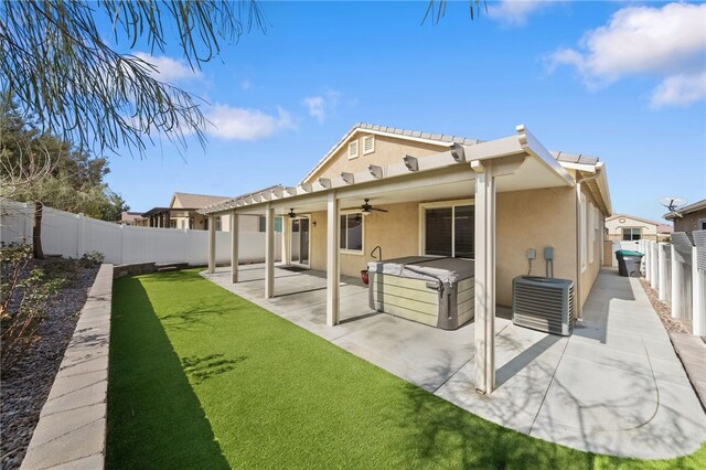 rear view of house with a yard, a patio area, a hot tub, and ceiling fan